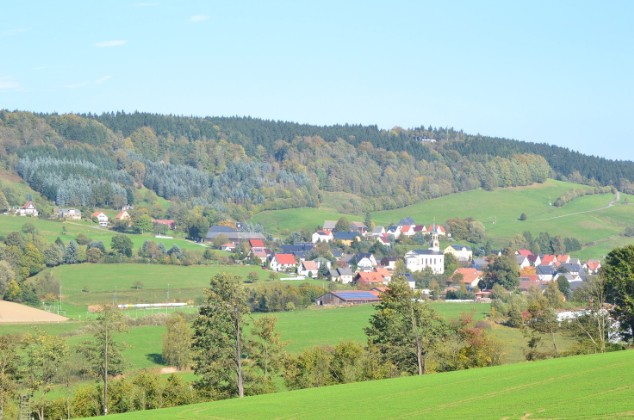 Saupsdorf mit Dorfkirche und herbstlich gefärbtem Wachberg